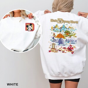 May include: White sweatshirt featuring a Mickey Mouse graphic on the front and a colorful Walt Disney World map design on the back. The sweatshirt has a crew neck and long sleeves. The word "WHITE" is printed at the bottom.