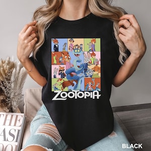 May include: Black t-shirt featuring a colorful graphic of characters from the animated movie "Zootopia". The design includes a snake and various animal characters in a grid pattern, with the word "Zootopia" in white text.