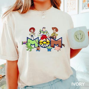 a woman wearing a t - shirt with cartoon characters on it