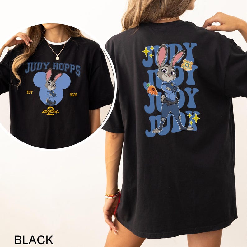 May include: Black t-shirt with a Judy Hopps design from Zootopia. The front displays "JUDY HOPPS" and a cartoon Judy image. The back features a larger Judy illustration in her police uniform, with the name "JUDY" repeated in a blue font.
