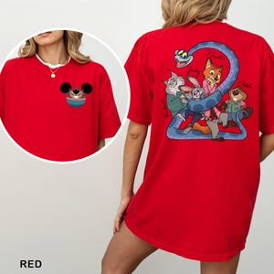 May include: Red t-shirt featuring a cartoon graphic of Mickey Mouse on the front pocket and a group of cartoon characters on the back. The text "RED" is at the bottom of the image.