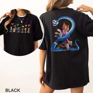 Op de afbeelding: Zwart T-shirt met cartoonontwerpen op de voor- en achterkant. De voorkant heeft cartoonfiguren en hartvormen. De achterkant toont een vos, een konijn en een slang. Het woord "BLACK" staat onderaan afgedrukt.