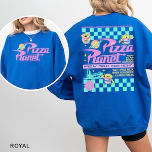 May include: Royal blue sweatshirt featuring the Pizza Planet logo in pink and white on the front and back. The back design includes alien characters, a checkered pattern, and text promoting "Friday Night Kids Night."
