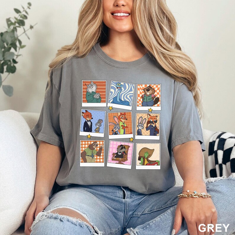 May include: Grey t-shirt featuring a collage of cartoon animal characters in polaroid-style frames. The characters include a fox, rabbit, and other animals. The word "GREY" is printed at the bottom right.