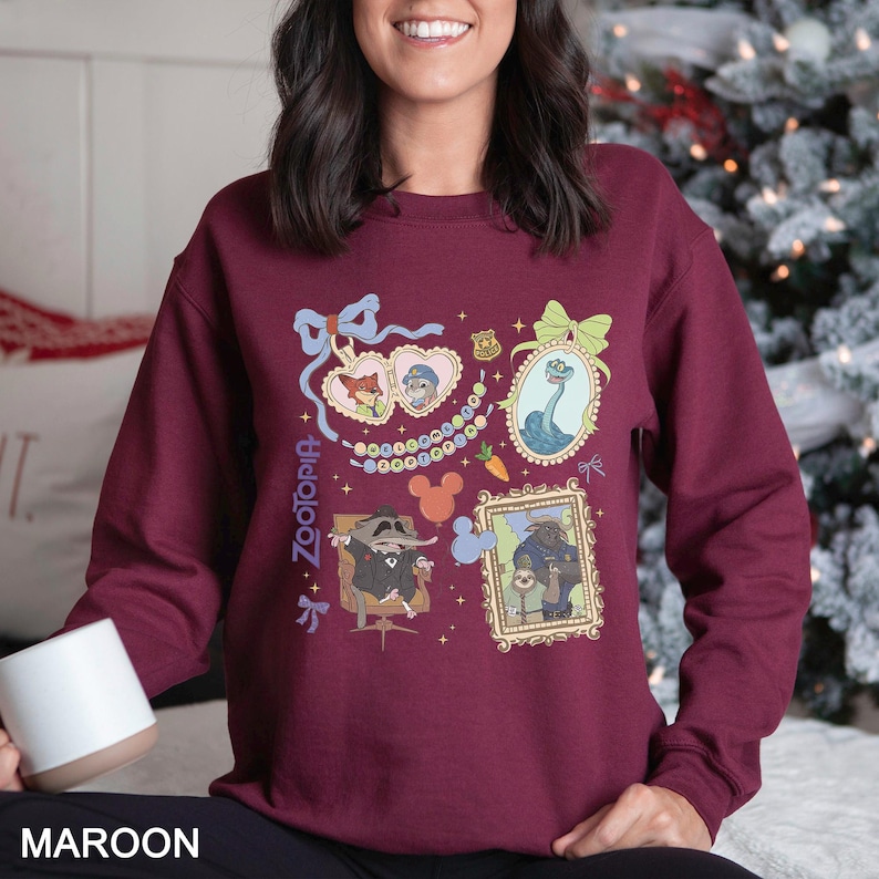 以下が含まれることがあります： 映画「ズートピア」の漫画のキャラクターイラストが特徴のマルーン色のスウェットシャツ。デザインには、額入りの肖像画、ハート、そして「Zootopia」の文字が含まれています。スウェットシャツは無地のマルーン色です。