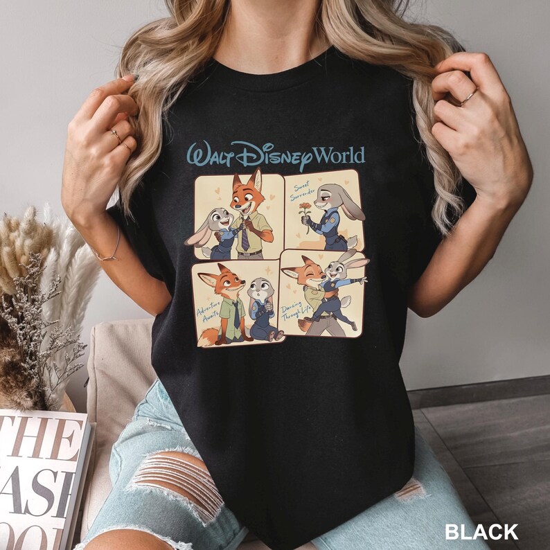 K&ouml;nnte beinhalten: Schwarzes T-Shirt mit einem viergeteilten Grafikdesign von Zootopia-Charakteren und dem Text "Walt Disney World" dar&uuml;ber. Die Panels zeigen Nick Wilde und Judy Hopps in verschiedenen Posen. Das Wort "BLACK" ist unten aufgedruckt.