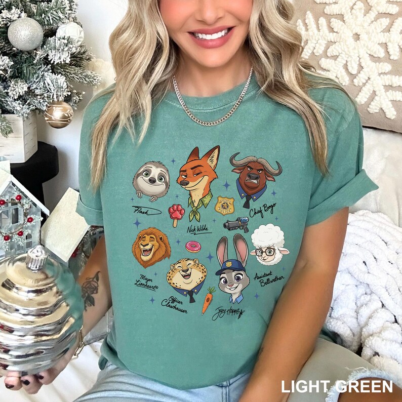 K&ouml;nnte beinhalten: Hellgr&uuml;nes T-Shirt mit Zeichentrickfiguren aus Zootopia, darunter Flash, Nick Wilde und Judy Hopps. Das Shirt hat unten den Text "LIGHT GREEN".