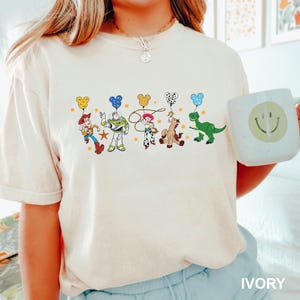 a woman holding a coffee mug with cartoon characters on it