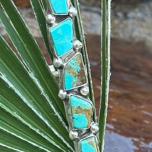 May include: A white ceramic mug with a black handle and the text "But First, Coffee" in a black, handwritten-style font. The mug is on a white surface.