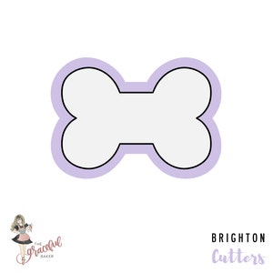 May include: A purple outline of a dog bone cookie cutter. The cookie cutter is a simple shape with rounded edges.