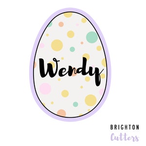 May include: A pastel pink, yellow, and green polka dot Easter egg cookie cutter with the name "Wendy" written in black script. The cutter is outlined in black and has a light purple border. The text "Brighton Cutters" is written in black below the egg.