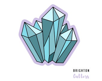 Könnte beinhalten: Ein Ausstechförmchen in Form eines Kristallclusters mit scharfen geometrischen Facetten in hellen und dunklen Blautönen. Die Form hat einen dicken, hellvioletten Rand und der Text BRIGHTON CUTTERS steht unten rechts im Bild.