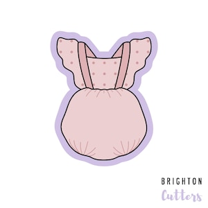 May include: A light pink baby romper cookie cutter with a ruffled top and polka dot accents. The romper has suspender straps and a rounded bottom. The cutter is outlined in black and purple, with the text "BRIGHTON Cutters" at the bottom.