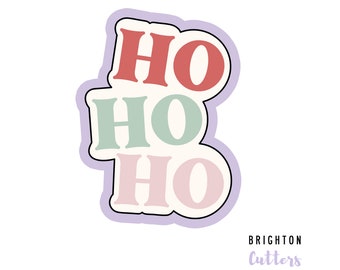 May include: A cookie cutter with a light purple outline and a white background featuring the text HO HO HO in stacked rows. The top HO is red, the middle HO is sage green, and the bottom HO is light pink. The text BRIGHTON Cutters appears below.