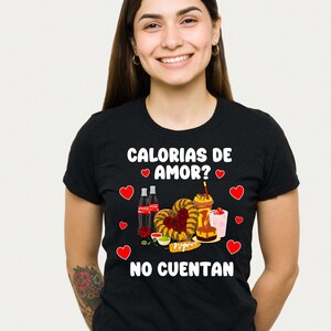 May include: Black t-shirt with a white graphic of Mexican food and the text "Calorias de amor? No cuentan".