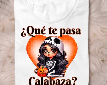 May include: A white t-shirt with a black and orange graphic of a skeleton girl holding a pumpkin. The text on the shirt reads "¿Qué te pasa Calabaza?"