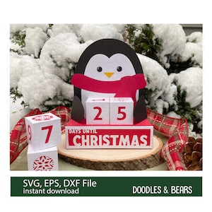 May include: A red and white penguin-shaped countdown calendar with the words "Days Until Christmas" and the numbers "25" displayed. The calendar is sitting on a wooden base with a red and white checked ribbon.
