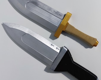 Puede incluir: Dos dagas plateadas con hojas puntiagudas y empuñaduras texturizadas. Una daga tiene un mango dorado y beige, la otra un mango negro. Las hojas tienen flechas grabadas.