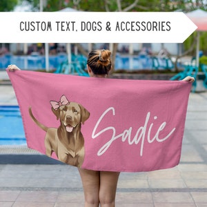 Può includere: Asciugamano da spiaggia rosa con un'illustrazione di un cane marrone che indossa un fiocco rosa. Il nome del cane, Sadie, è scritto in corsivo bianco sull'asciugamano.