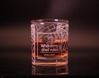 May include: A clear glass tumbler with a white design that says "Where my chef rules" and a brown liquid inside.