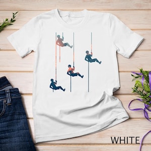 Könnte beinhalten: Weißes T-Shirt mit einer Grafik von vier Personen, die an Seilen abseilen. Die Grafik ist in Schwarzweiß und der Hintergrund ist ein Farbverlauf von Orange, Rosa und Blau.
