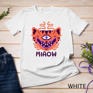 Maglietta con design stravagante per il pubblico americano, con gatto con un occhio solo e cartone animato