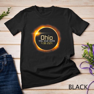May include: Black t-shirt with a graphic of a solar eclipse over the word "Ohio" and the text "Total Solar Eclipse 4.08.2024".