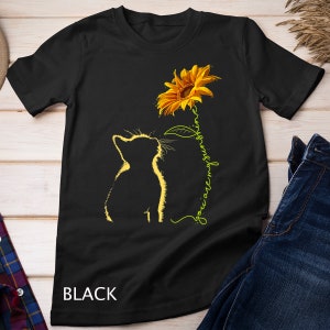 K&ouml;nnte beinhalten: Schwarzes T-Shirt mit einer Silhouette einer Katze, die zu einer gelben Sonnenblume aufblickt, mit dem Text "you are my sunshine" in Gr&uuml;n.