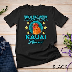 May include: Black t-shirt with a rooster illustration and the text "World's Most Annoying Alarm Clock Kauai Hawaii".