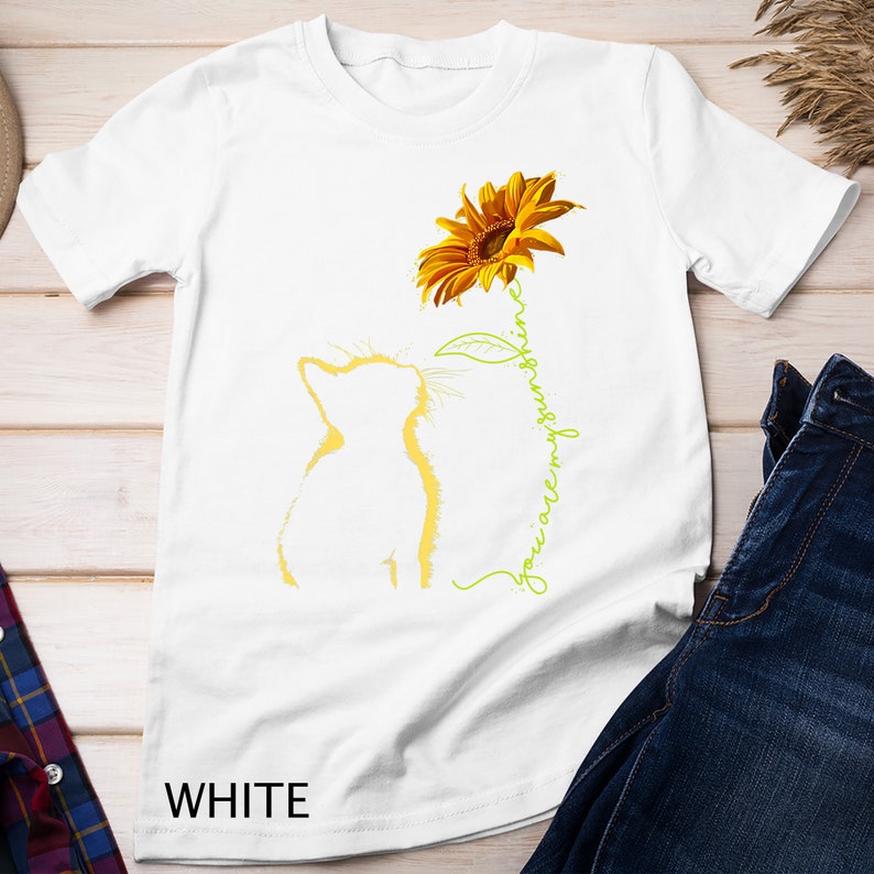 K&ouml;nnte beinhalten: Wei&szlig;es T-Shirt mit einer gelben Sonnenblume und einer Katzensilhouette. Der Text "You are my sunshine" ist in gr&uuml;ner Kursivschrift geschrieben.