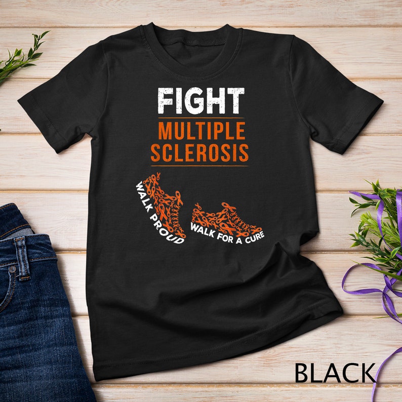 Op de afbeelding: Zwart T-shirt met de tekst "FIGHT MULTIPLE SCLEROSIS" en twee oranje sneakers gemaakt van oranje bewustzijn lintjes. De tekst op de sneakers luidt "WALK PROUD" en "WALK FOR A CURE".