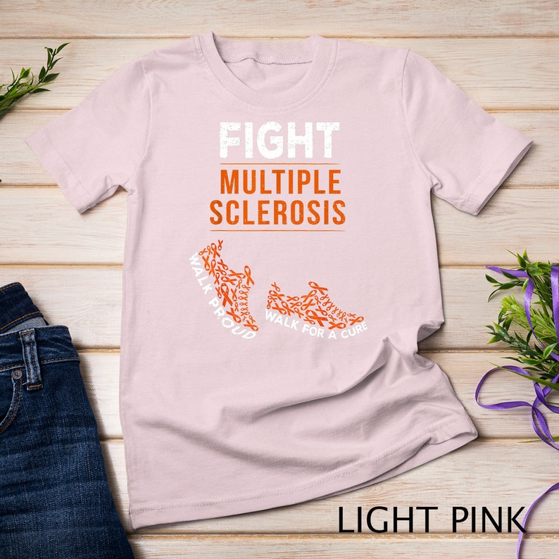 Op de afbeelding: Licht roze T-shirt met de tekst "FIGHT MULTIPLE SCLEROSIS" en twee hardloopschoenen gemaakt van oranje bewustzijn lintjes. De tekst op de schoenen luidt "WALK PROUD" en "WALK FOR A CURE".