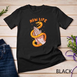 May include: Black t-shirt with a graphic of two hands clasped together with a snake wrapped around them. The text "NEW LIFE" is above the graphic.