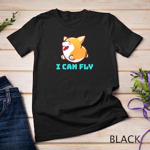 May include: Black t-shirt with a cartoon image of a corgi dog with the text "I can fly" in turquoise.