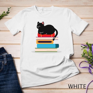 Chat noir fantaisiste se prélassant sur une pile de livres colorés - T-shirt idéal pour les amateurs de lecture