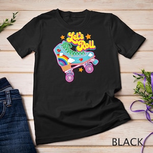 Może przedstawiać: Czarny T-shirt z grafiką rolki z tęczowymi akcentami i tekstem "Let's Roll".