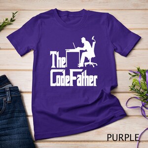May include: Purple t-shirt with a white silhouette of a person sitting at a desk with a laptop and the text "The CodeFather".