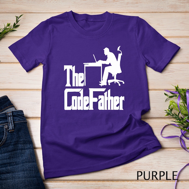 May include: Purple t-shirt with a white silhouette of a person sitting at a desk with a laptop and the text "The CodeFather".
