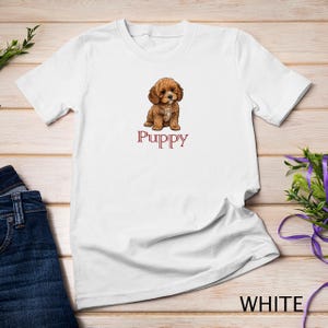 May include: White t-shirt with a brown and white puppy illustration and the word "Puppy" printed in red.