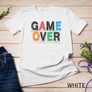Las leyendas de los videojuegos pixelados abrazan la era digital con una camiseta sudadera con letras icónicas