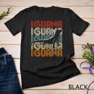 Puede incluir: Camiseta negra con un gráfico retro de una iguana y la palabra "Iguana" repetida cuatro veces.