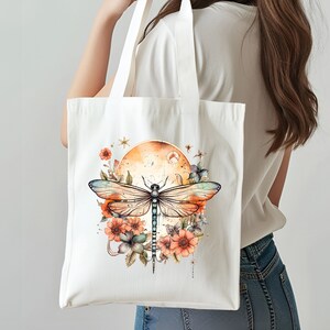 Pu&ograve; includere: Una borsa tote in tela bianca con un design di libellula e fiori. La libellula &egrave; blu e verde con ali arancioni. I fiori sono arancioni, rosa e bianchi. Lo sfondo &egrave; di un colore arancione chiaro.