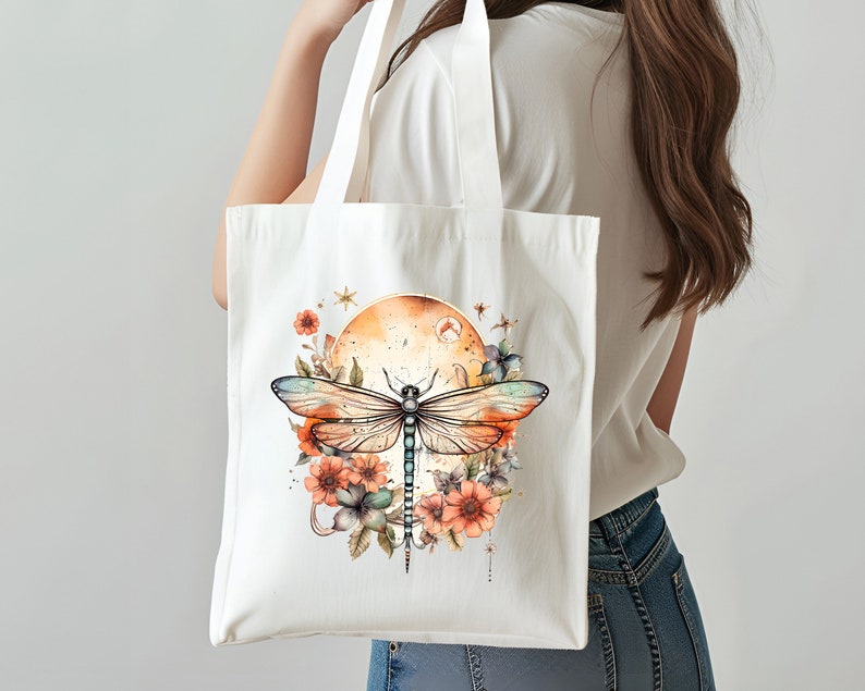 Pu&ograve; includere: Una borsa tote in tela bianca con un design di libellula e fiori. La libellula &egrave; blu e verde con ali arancioni. I fiori sono arancioni, rosa e bianchi. Lo sfondo &egrave; di un colore arancione chiaro.