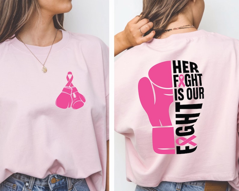 Pode incluir: T-shirt rosa claro com um design de luva de boxe rosa e uma fita rosa na frente. A parte de tr&aacute;s da camisa exibe uma luva de boxe rosa e o texto "HER FIGHT IS OUR FIGHT" em preto.
