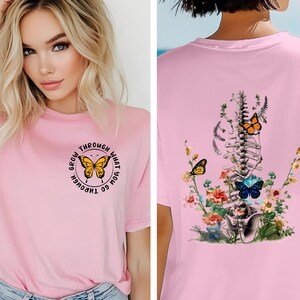 May include: Pink t-shirt with a butterfly graphic and the text "Grow through what you go through". The back of the shirt features a floral design with a butterfly and a skeletal spine.