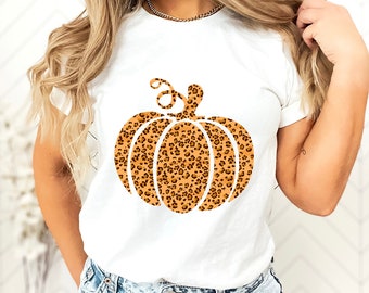 May include: White t-shirt with a brown and orange leopard print pumpkin graphic.