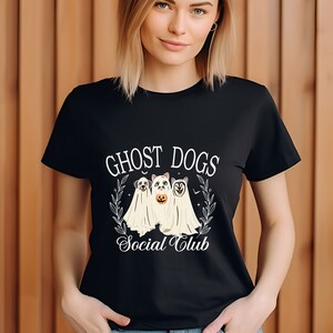 May include: Black t-shirt with a white graphic of three dogs dressed as ghosts. The text "Ghost Dogs Social Club" is printed below the dogs.