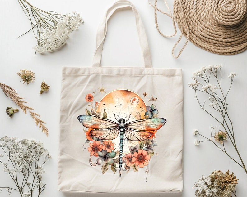 Pu&ograve; includere: Una borsa tote in tela bianca con un design di libellula e fiori. La libellula &egrave; blu, verde e arancione con un effetto acquerello. I fiori sono rosa, arancioni e gialli. Lo sfondo &egrave; un acquerello arancione e giallo.