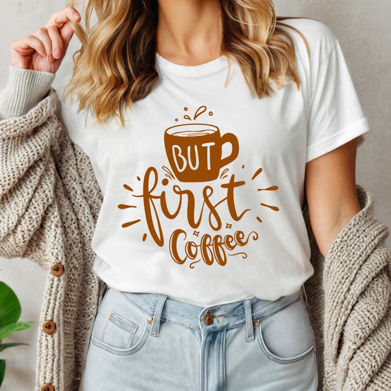 May include: White t-shirt with a brown coffee cup graphic and the text "BUT first Coffee". The shirt is made of a soft material and is suitable for casual wear.