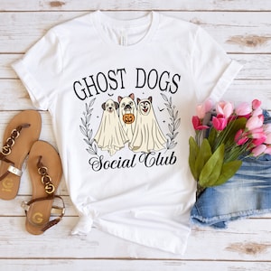 May include: White t-shirt with a black graphic of three ghost dogs with the text "Ghost Dogs Social Club".